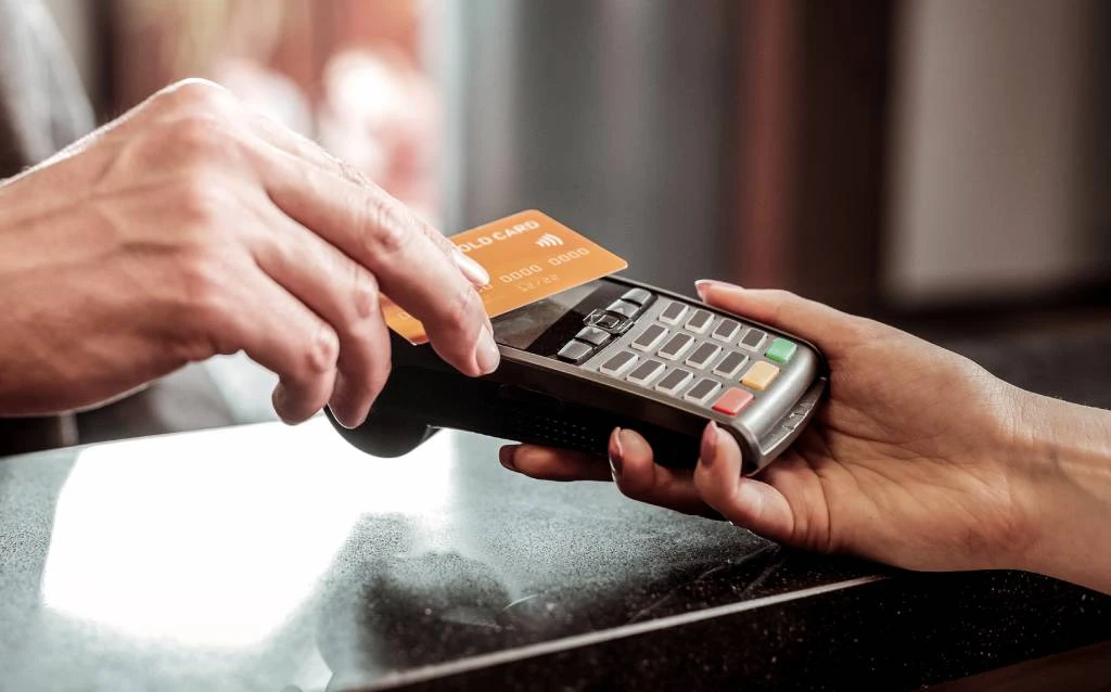 Un cliente que paga con una máquina de tarjetas de crédito sin contacto