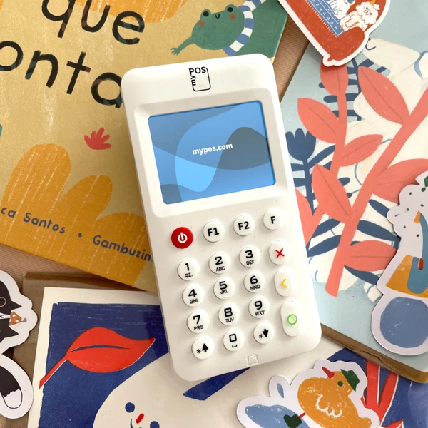 Le propriétaire d'une petite entreprise utilise l'appareil myPOS sur un marché de l'art